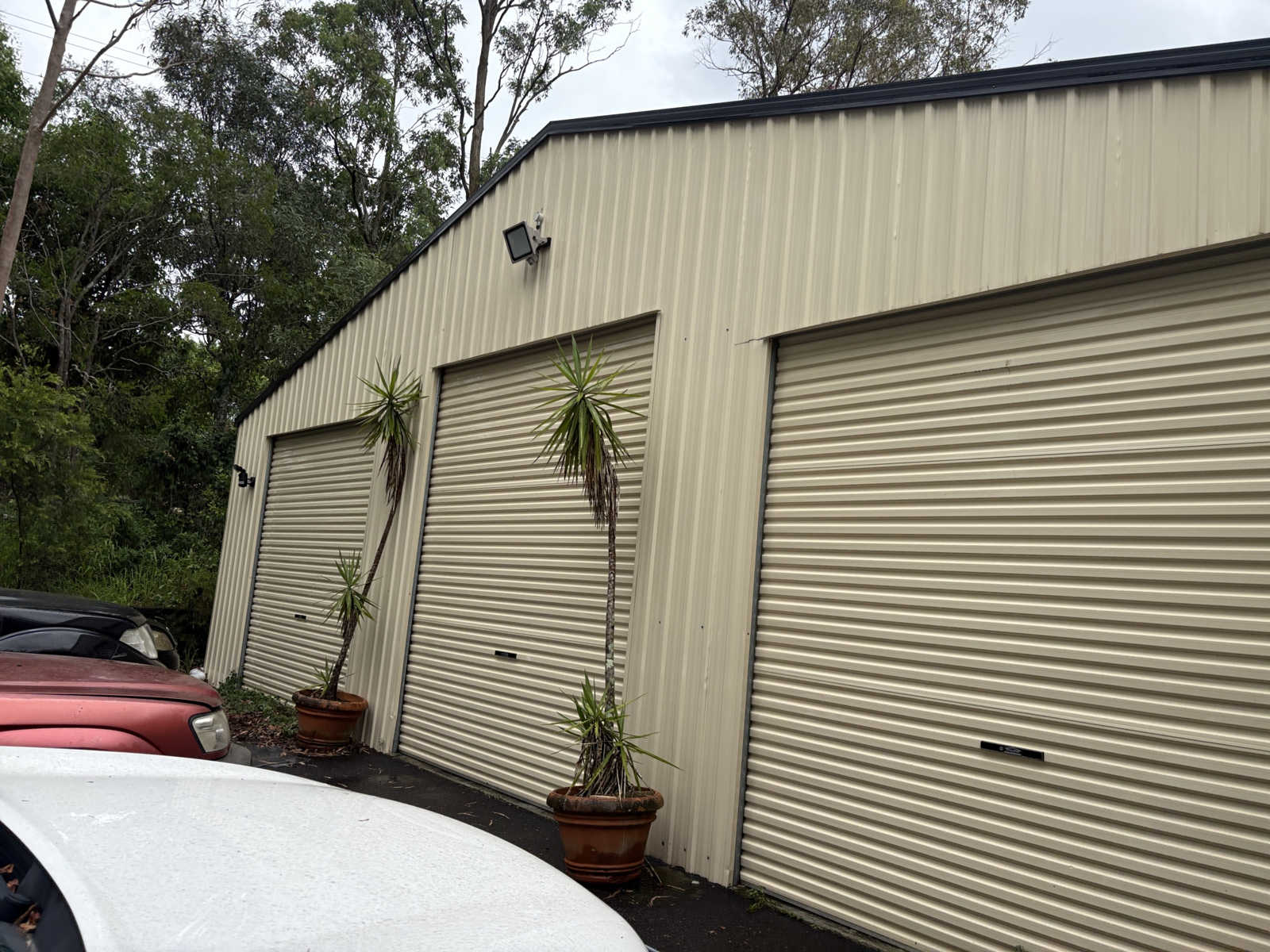Commercial shed exterior after cleaning, doors and walls restored to clean beige finish