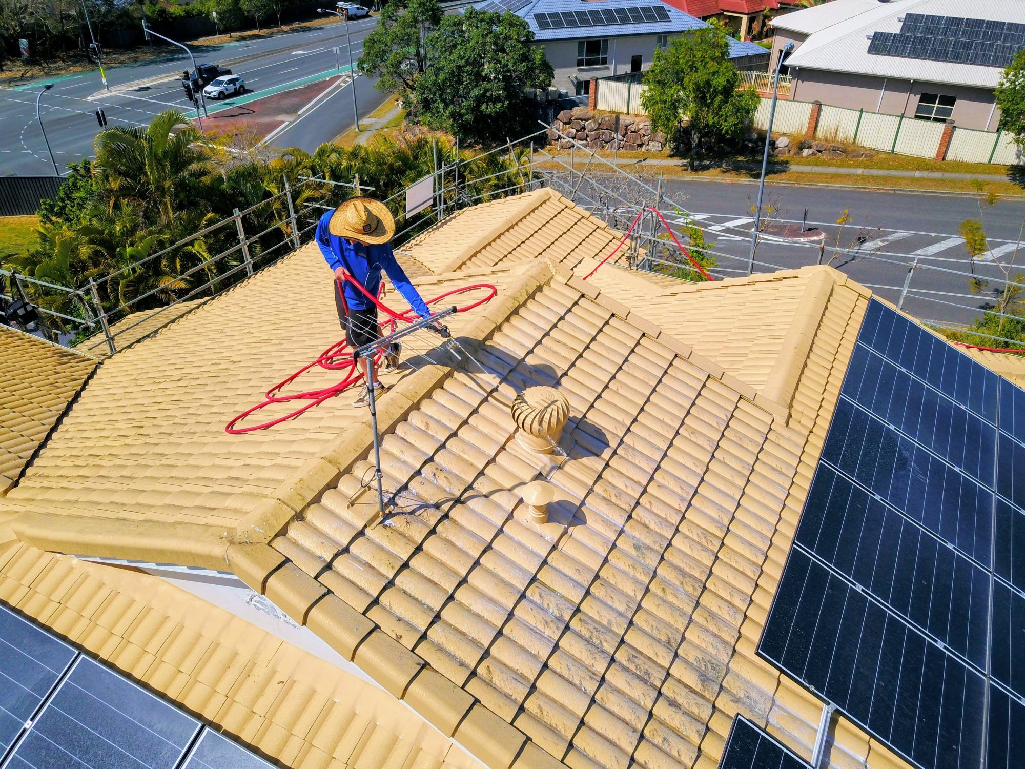 Technician soft washing a tiled roof in Brisbane
