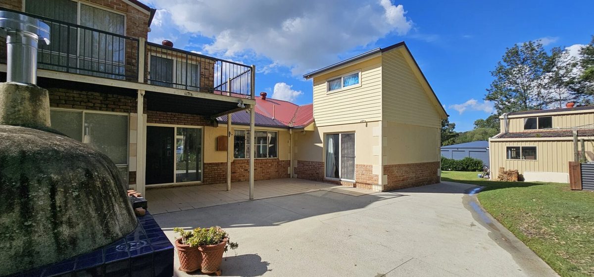 Two-storey rendered home with a paved backyard